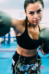 Portrait of female boxer throwing punch - CUF48242