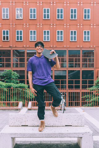 Skateboarder posing with skateboard, Milan, Italy stock photo