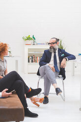 Geschäftsleute und Frau diskutieren bei einer Besprechung auf einem Bürosofa, Ausschnitt - CUF48256