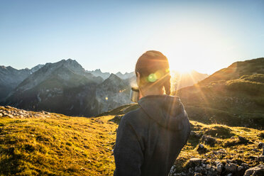 Hiker taking break with warm drink, Karwendel region, Hinterriss, Tirol, Austria - CUF48302