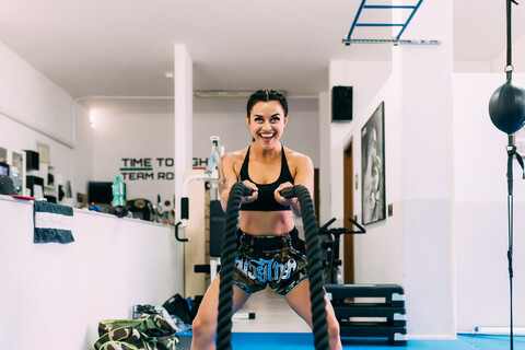 Frau benutzt Seilpeitschen beim Training im Fitnessstudio, lizenzfreies Stockfoto