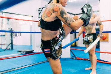 Male and female boxers working out in boxing ring - CUF48411