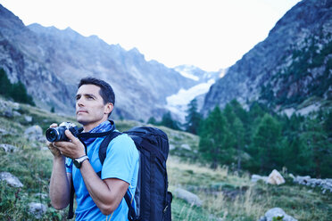 Hiker taking photograph, Mont Cervin, Matterhorn, Valais, Switzerland - CUF48421