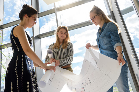 Kollegen rollen nach dem Brainstorming Charts auf, lizenzfreies Stockfoto