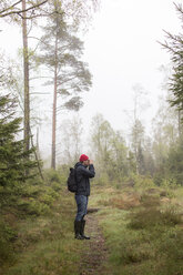 Mittlerer erwachsener Mann in einem nebligen Wald in Lerum, Schweden - FOLF10253