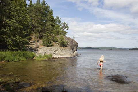 Mädchen watet im Meer in Mjorn, Schweden, lizenzfreies Stockfoto