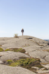 Mädchen geht über eine Felsformation in Bohuslan, Schweden - FOLF10261