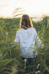 Junge Frau, die durch ein Grasfeld in Karlskrona, Schweden, läuft - FOLF10287
