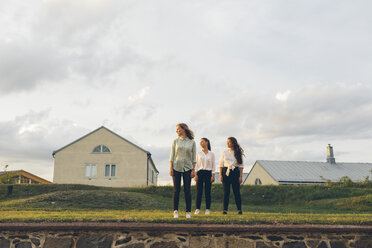 Drei junge Frauen stehen auf einer Mauer in Karlskrona, Schweden - FOLF10290