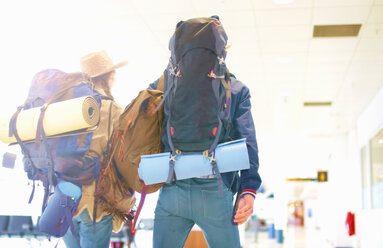 Junges Paar am Flughafen, mit Rucksäcken, Rückansicht - ISF20119