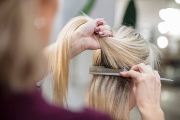 Hairdresser styling customer's hair in salon - ISF20147