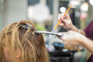 Friseurin beim Färben der Haare einer Kundin im Friseursalon - ISF20152