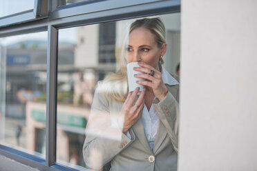 Geschäftsfrau macht Kaffeepause im Büro - ISF20158