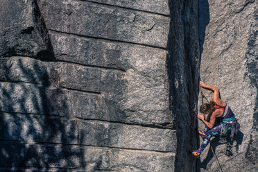Young female rock climber climbing rock face, Smoke Bluffs, Squamish, British Columbia, Canada - ISF20192