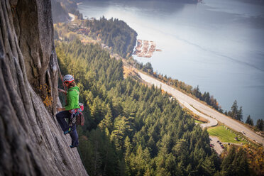 Young female rock climber climbing rock face, elevated view, The Chief, Squamish, British Columbia, Canada - ISF20197