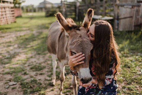 Frau küsst Esel, lizenzfreies Stockfoto