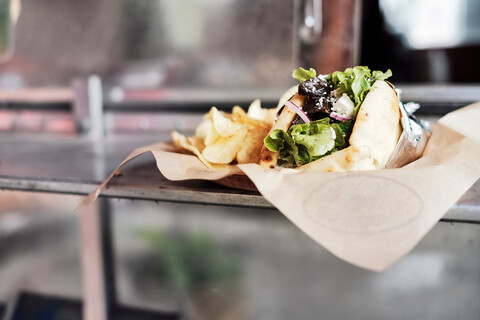 Mahlzeit aus Salatwrap und Kartoffelchips auf der Theke, lizenzfreies Stockfoto