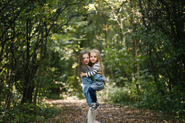 Schwestern umarmen sich im Wald - ISF20308
