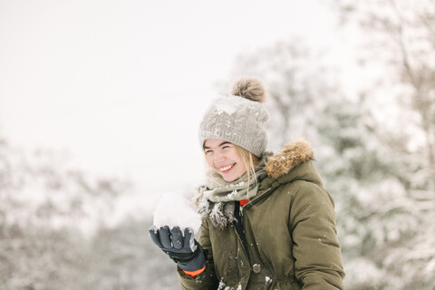 Girl with snow ball in winter landscape stock photo