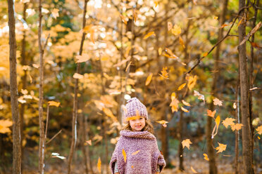 Falling autumn leaves in front of little girl in forest - ISF20393