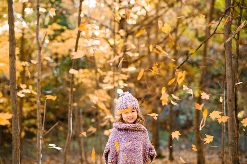 Fallende Herbstblätter vor einem kleinen Mädchen im Wald - ISF20393