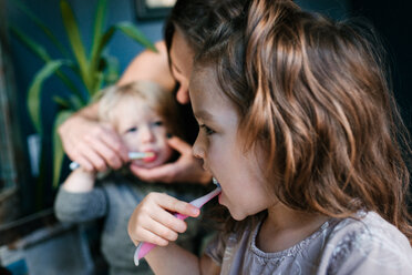 Mother helping children brush teeth - ISF20396