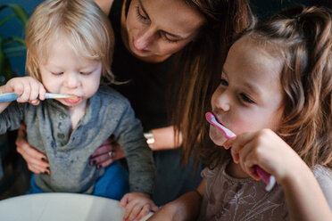 Mutter hilft Kindern beim Zähneputzen - ISF20397