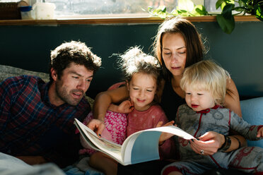 Eltern, die ihren Kindern im Bett vorlesen - ISF20398