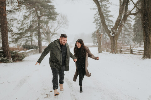 Paar läuft in verschneiter Landschaft, Georgetown, Kanada, lizenzfreies Stockfoto