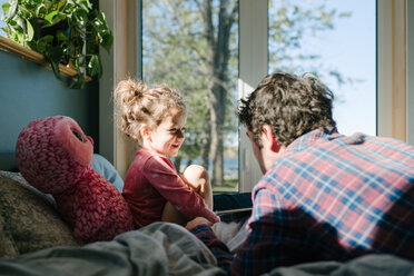 Vater und Tochter unterhalten sich im Bett - ISF20407