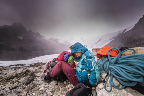 Felskletterer mit Kletterausrüstung, die vor extremen Wetterbedingungen schützt, El Chaltén, Südpatagonien, Argentinien - ISF20421