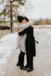 Sich umarmendes Paar in verschneiter Landschaft, Georgetown, Kanada - ISF20490
