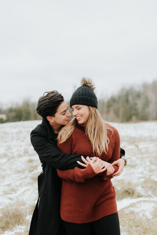 Sich umarmendes Paar in verschneiter Landschaft, Georgetown, Kanada, lizenzfreies Stockfoto