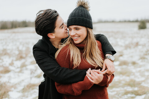 Sich umarmendes Paar in verschneiter Landschaft, Georgetown, Kanada, lizenzfreies Stockfoto