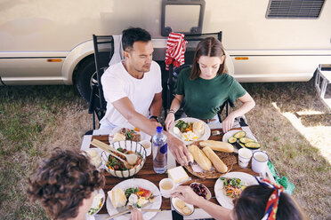 High angle view of parents and children having food at table in campsite - MASF10973