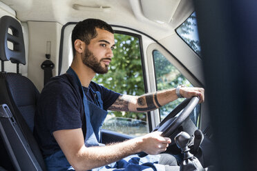 Seitenansicht eines selbstbewussten jungen männlichen Besitzers, der einen Imbisswagen in der Stadt fährt - MASF11008