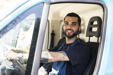 Porträt eines selbstbewussten jungen Mannes, der einen Imbisswagen in der Stadt fährt - MASF11009