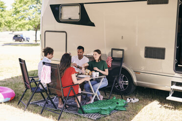 Familie in voller Länge mit Essen gegen Van beim Camping im Wohnwagenpark - MASF11024