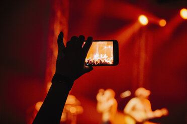 Hand im Publikum, die ein Musikkonzert mit der Handykamera aufnimmt - FSIF03759