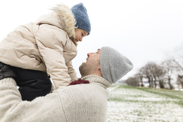 Happy father carrying daughter in winter - KMKF00679