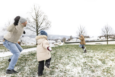 Vater und zwei Kinder liefern sich eine Schneeballschlacht - KMKF00681