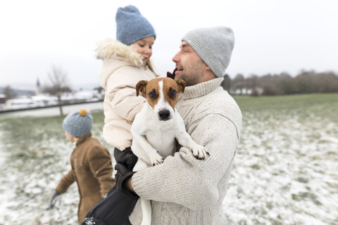 Vater mit zwei Kindern und Hund in Winterlandschaft, lizenzfreies Stockfoto