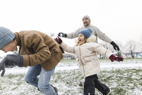 Vater und zwei Kinder liefern sich eine Schneeballschlacht - KMKF00690