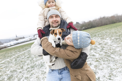 Father with two children and dog in winter landscape stock photo