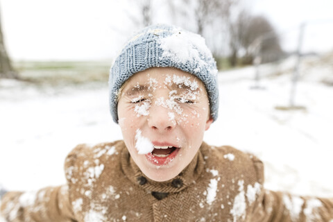 Porträt eines Jungen mit Schnee im Gesicht, lizenzfreies Stockfoto