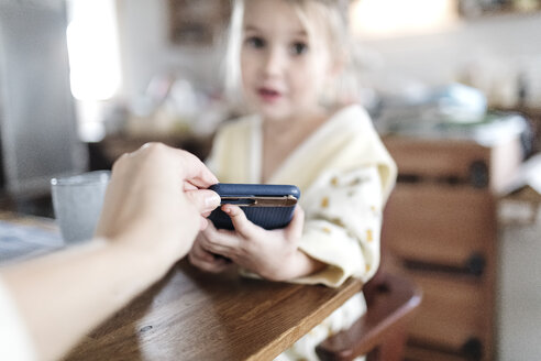 Die Hand der Mutter nimmt das Smartphone weg, Nahaufnahme - KMKF00717