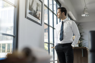 Selbstbewusster Geschäftsmann steht im Büro und schaut aus dem Fenster - SBOF01567