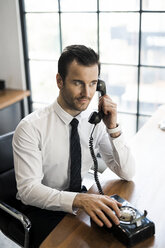 Businessman in office using vintage retro telephone - SBOF01569