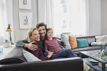 Portrait of happy family sitting on couch at home - RORF01582