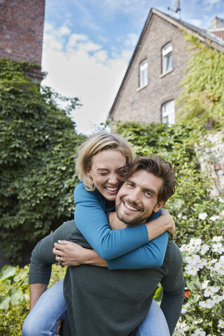 Portrait of happy couple in garden of their home stock photo